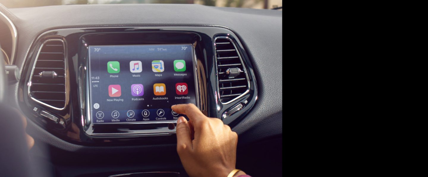 A close-up of the touchscreen in the 2020 Jeep Compass with smartphone integration icons displayed.