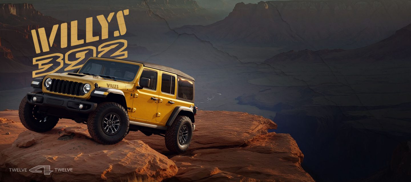 A driver-side front angle of a gold 2026 Jeep Wrangler Willys 392 crawling up a steep, rocky trail. Willys 392. 12 for 12.