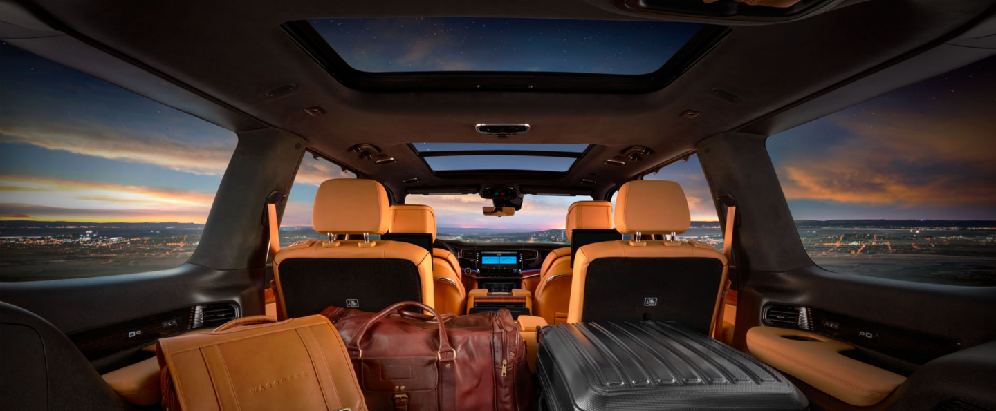 The cargo area of the 2023 Grand Wagoneer with the second and third rows folded and several suitcases in the hold.